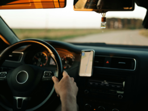  Summer driving showing safe hands on the wheel in a car, with a phone stand. 