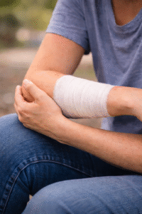 Person holding a bandaged arm after an animal bite injury