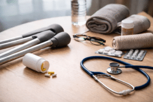 Recovery after personal injury with crutches, medication, bandages, and a stethoscope on a wooden table.