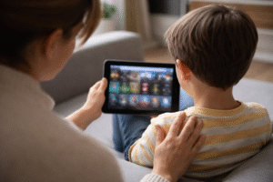 Parent sitting with child using a tablet, related to concerns behind Roblox predator lawsuits.