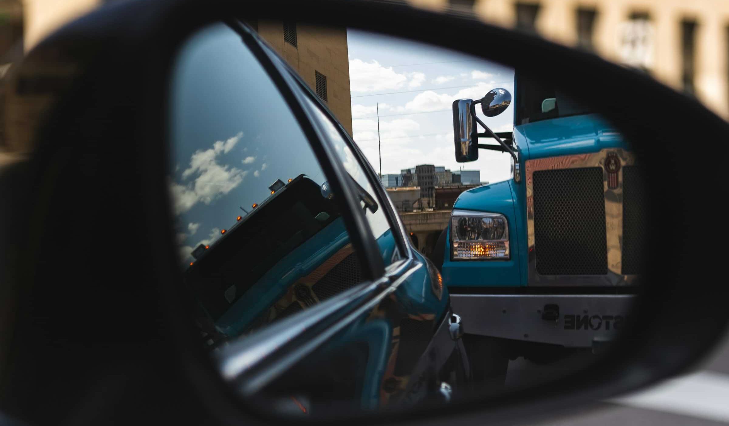 large semi-truck in car rearview mirror